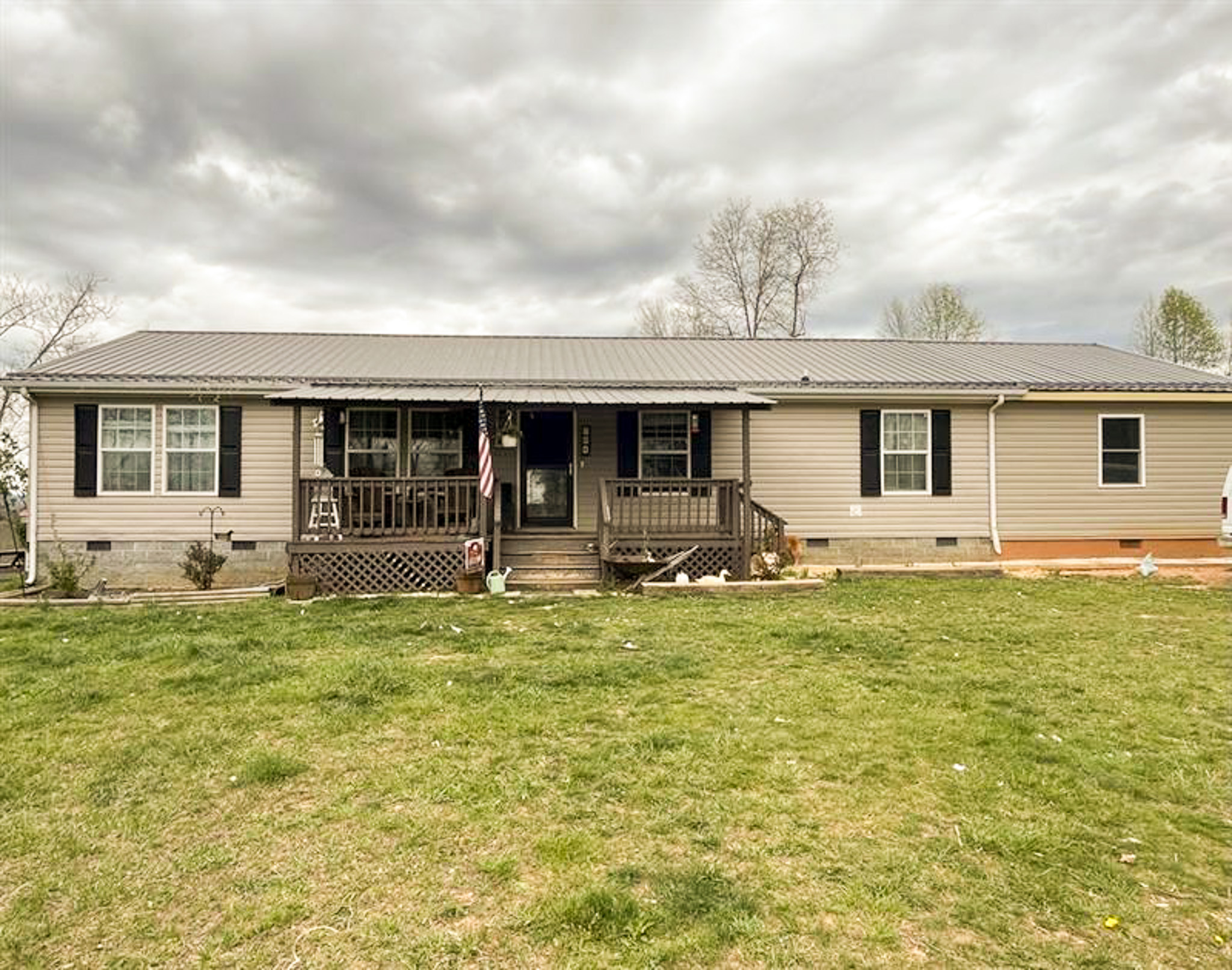 Single-story ranch-style home with front porch, metal roof, and grassy yard under cloudy sky belonging to Sponsored Residential Provider Kristen Bowers in Galax, Virginia.