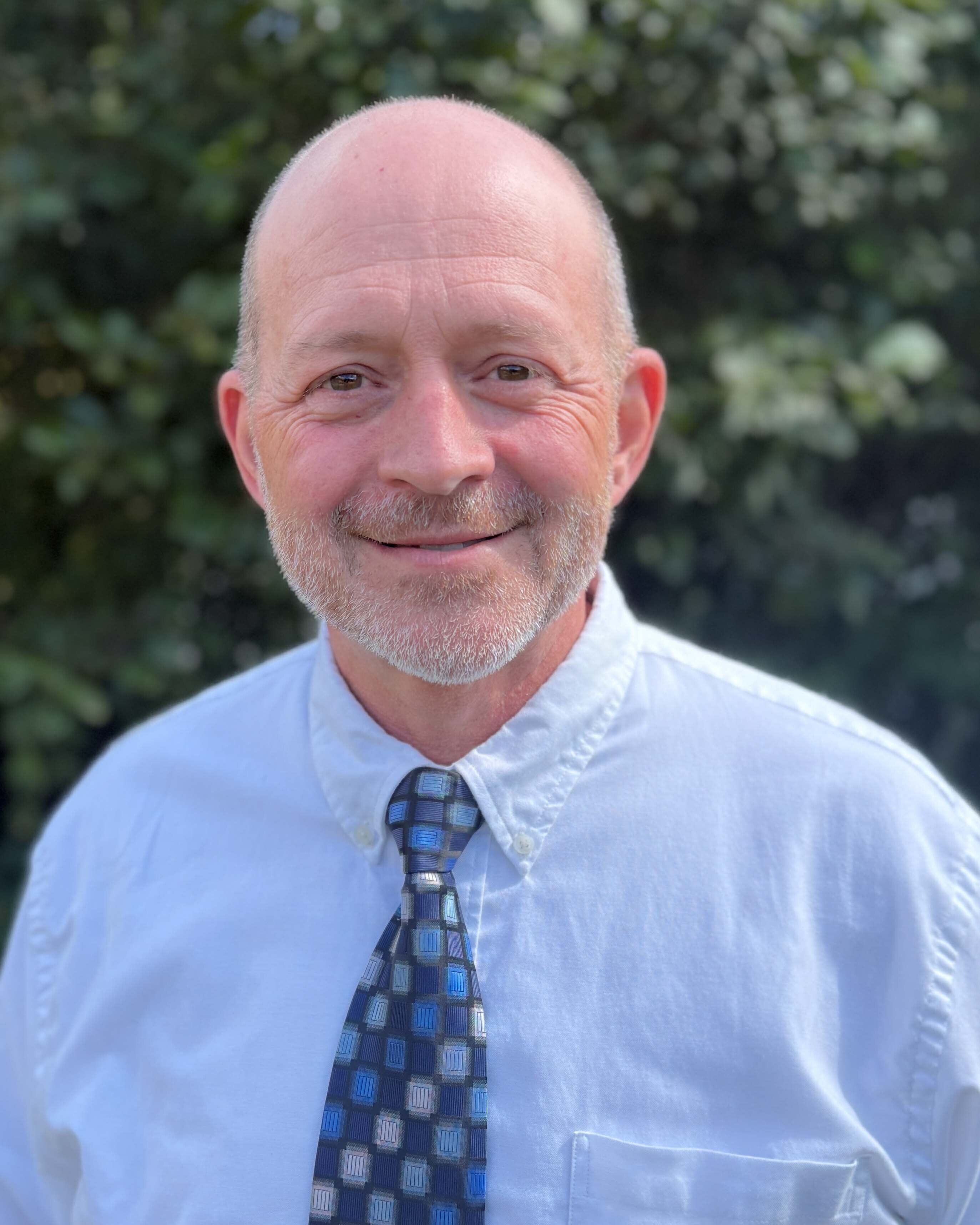 Wall CEO & President John Weatherspoon in front of a green natural outdoor background