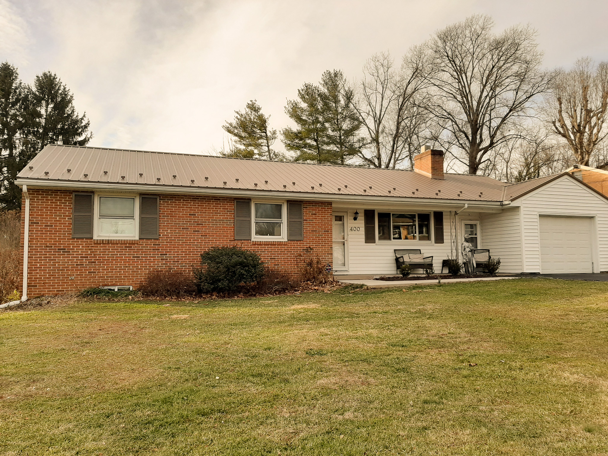 Single‑story brick home with light siding, metal roof, attached garage, and a grassy front yard belonging to Sponsored Residential Provider Rhonda Kestner in Staunton, VA.