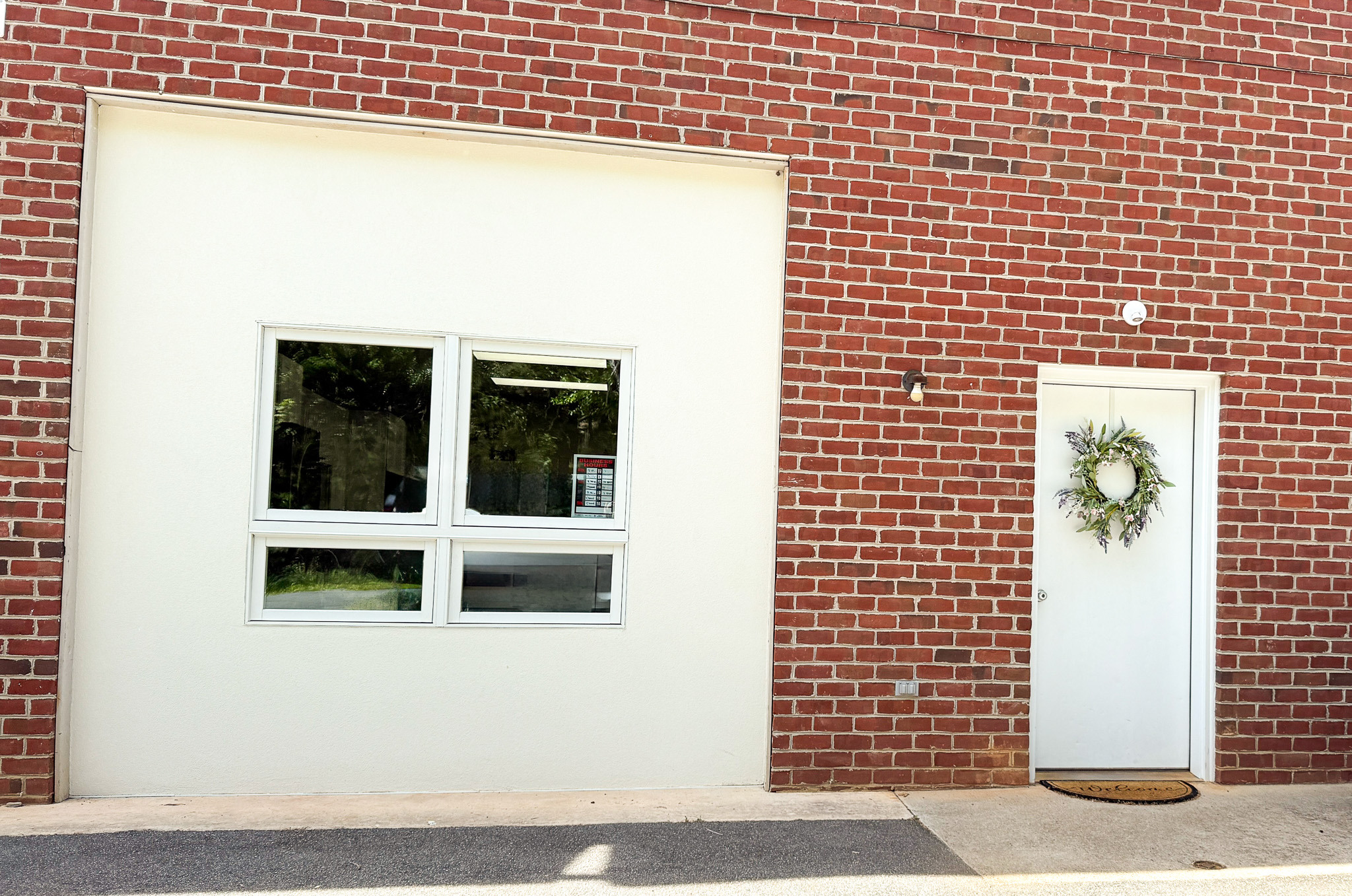 Brick building with white inset area around large window and white door with wreath that is the entrance to the Madison Heights Star Center Day Support.