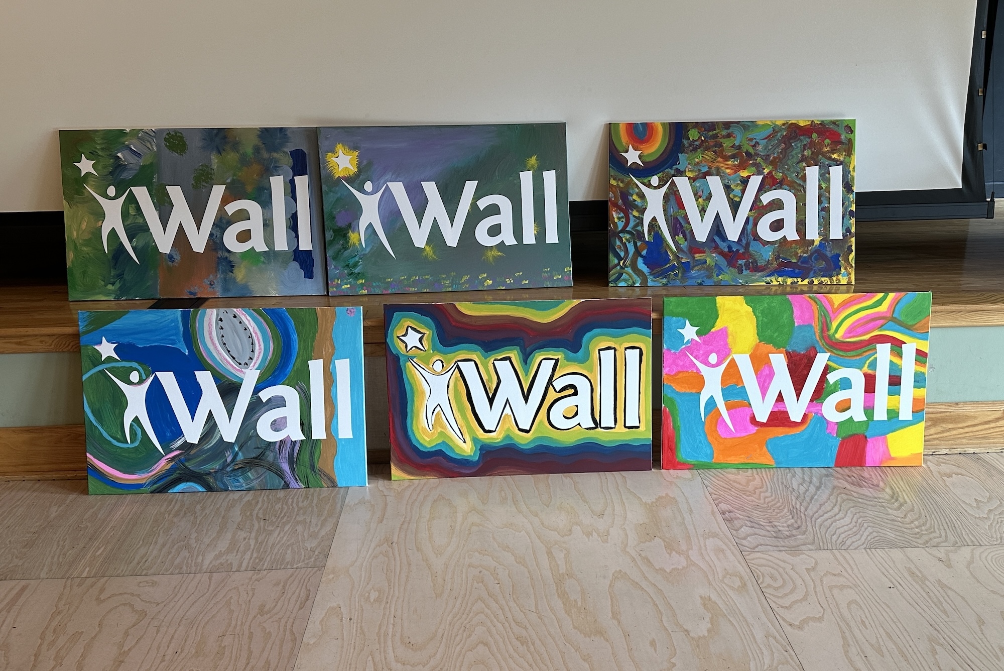 Six colorful canvas paintings with Wall logo.