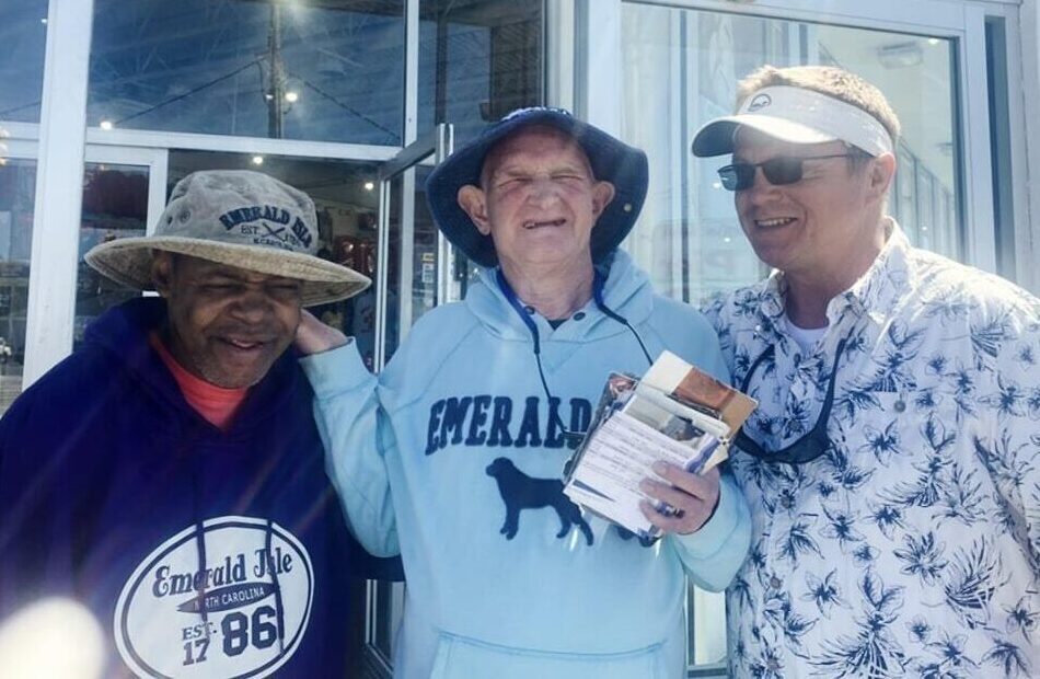 Three men smiling wearing hats outside