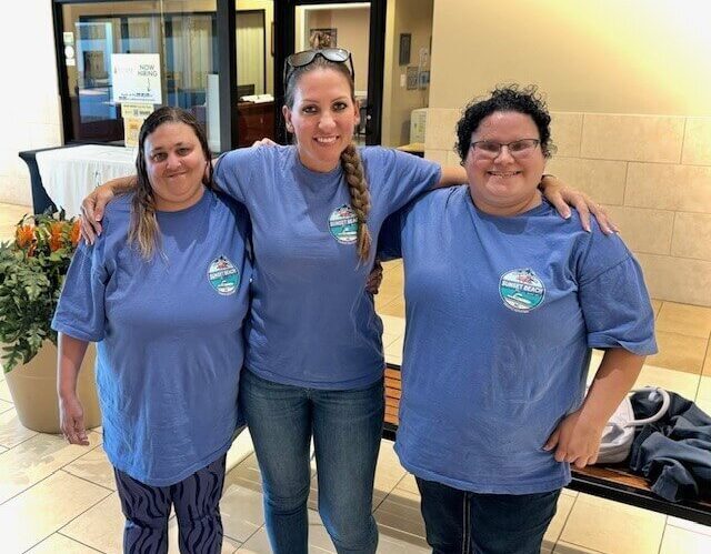Two individuals and a Wall Residences provider wearing matching shirts next to each other